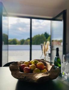 纳尔巴赫Ferienwohnung Nalbach Wohnung 1的桌上一碗苹果和一瓶葡萄酒