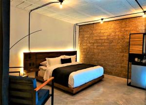 乔卢拉Hotel Tila的一间卧室设有一张床和砖墙