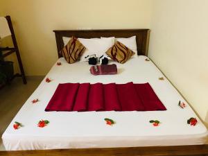 贾夫纳亚尔小镇酒店的一张铺有红色床单的床,上面装有红色的袋子