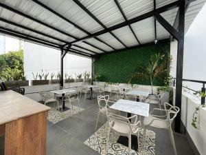 卡塔赫纳Hotel Amoek的一间带桌椅和绿色墙壁的餐厅