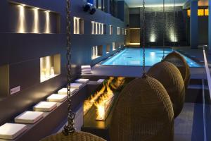 夏蒙尼-勃朗峰海利皮柯公寓的酒店游泳池设有椅子和壁炉