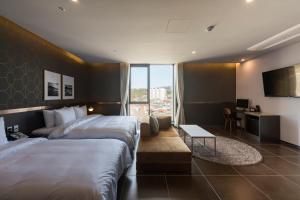 釜山Browndot hotel Guseo的酒店客房配有两张床和一张书桌