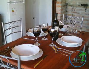泰马斯德瓜维尤Palmares Apart Termal的一张桌子,上面放着酒杯和一瓶葡萄酒