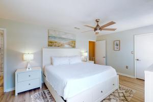沃尔顿堡滩Sugar Reef Cottage #4的卧室配有白色的床和吊扇