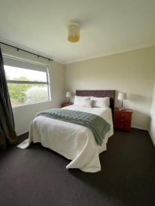 北帕默斯顿Benrose Park的一间卧室设有一张大床和一个窗户。