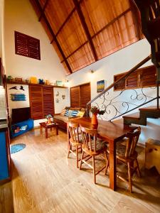 Serra de São BentoVila Feliz - Chalés completos - ideal para famílias的客厅设有木桌和楼梯。