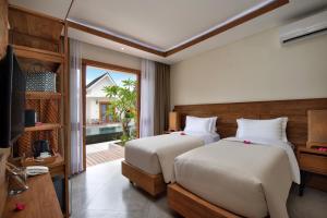 吉利特拉旺安蓬特别墅的一间卧室设有两张床、一台电视和一扇窗户。
