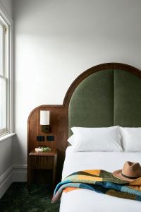 波塔灵顿Portarlington Grand Hotel的一间卧室,配有一张床,上面有帽子