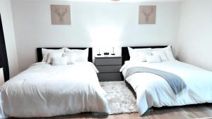 亚特兰大Highrise luxury two bedroom condo in Downtown Atlanta within minutes!!的卧室设有两张床,拥有白色的墙壁和木地板