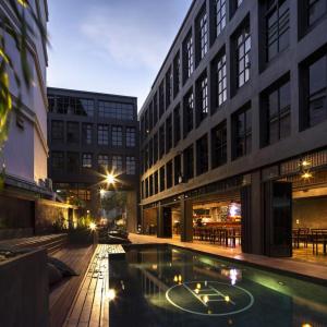 曼谷BED STATION Hostel Khaosan的一座大型建筑,前面设有一个游泳池