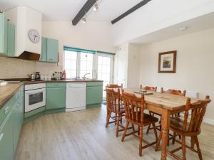 阿贝达隆Glan Felin的厨房配有绿色橱柜和木桌