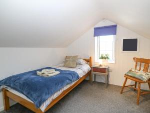 阿贝达隆Glan Felin的卧室配有床、椅子和窗户。