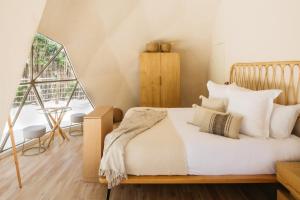 莫雷洛斯港Alma Maya Resort的一间卧室配有带白色床单和枕头的床。