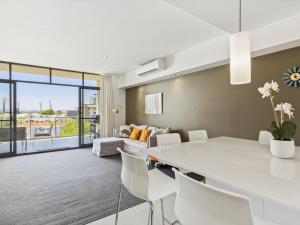 珀斯2bdrm Skyline Views - Prime for River, WACA, OPTUS Stadium的客厅配有白色的桌子和椅子