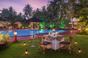 比纳里姆Fortune Resort Benaulim, Goa - Member ITC's Hotel Group的游泳池前的桌椅