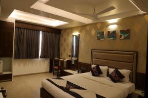 戈尔哈布尔Blisss Hotel Kolhapur的酒店客房设有两张床和天花板
