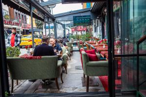 伊斯坦布尔Blue Zerzevan Konak Hotel的一群坐在餐厅外桌子上的人
