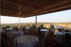 戈尔哈布尔Blisss Hotel Kolhapur的配有桌椅的客房享有田野景致。