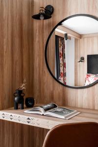 扎科帕内Willa Dunajec - Luxury Apartments的木桌上方的镜子和书