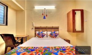 浦那FabExpress SRH Hinjewadi的一间卧室配有一张大床和色彩缤纷的被子