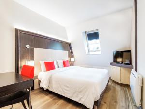 安锡邦留酒店的酒店客房配有一张床、一张书桌和一台电视。