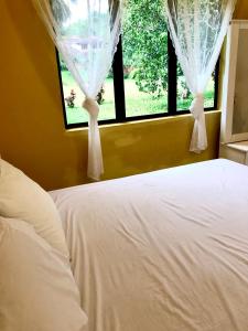 怡保Eco Resort Beverly Hills的卧室配有白色的床和窗户。
