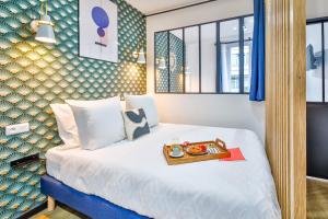 巴黎Apartments WS Hôtel de Ville - Beaubourg的一间酒店客房,配有一张床铺,上面放着一个食物托盘