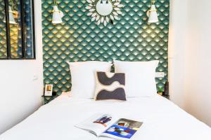 巴黎WS Hôtel de Ville - Beaubourg的一间卧室配有一张白色的床和绿色的墙壁