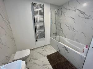 直布罗陀Modern Apartment with Spa and Pool的浴室配有卫生间、浴缸和水槽。