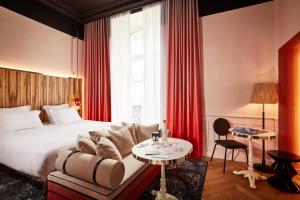 雷恩Mama Shelter Rennes的酒店客房配有床、沙发和桌子。
