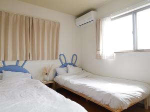 富士河口湖貸別荘 ウサギの郷的一间卧室设有两张床和窗户。