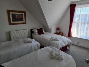韦茅斯Marden guest house的一间卧室设有两张床和窗户。