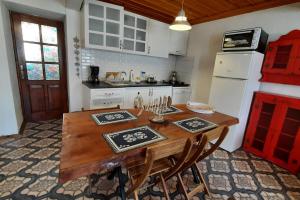 艾瓦勒克Old Stone House-Sea View (Rum Evi-Deniz Manzaralı)的厨房配有木桌、椅子和冰箱