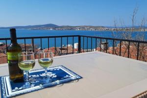 艾瓦勒克Old Stone House-Sea View (Rum Evi-Deniz Manzaralı)的桌子上放有一瓶葡萄酒和两杯酒
