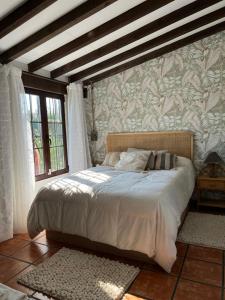 桑提亚纳德玛Posada La Fontana的一间卧室设有一张大床和墙壁