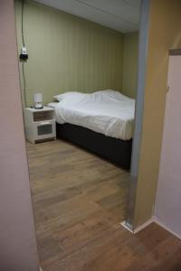 Ter Aarcamping family room的一间卧室配有一张床,铺有木地板