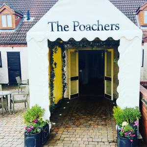 波士顿The Poachers Hotel的白色遮阳篷,上面写着门户