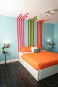 迈阿密海滩住宿加饮品酒店的一间卧室配有橙色床和条纹墙
