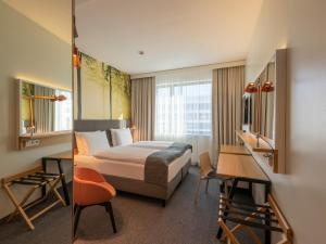 慕尼黑假日酒店慕尼黑 - 洛伊希滕贝格环路的配有一张床和一张书桌的酒店客房