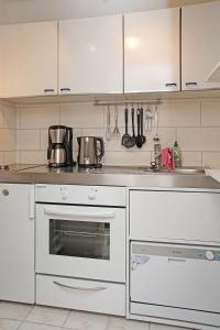 库克斯港Muschelsucher的厨房配有白色橱柜和白色烤箱