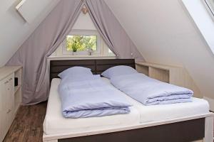 库克斯港Muschelsucher的窗户间内的一张带两个枕头的床