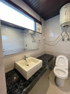 马拉里The Royal Majestic Mountain View的一间带水槽和卫生间的浴室以及窗户。