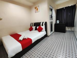 丹那拉打Ar Rayyan Hotel的一间卧室配有红色和白色枕头的床