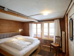 哈布凯恩Gästehaus Hof Maiezyt的一间卧室配有一张床、一把椅子和窗户。