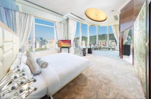 香港富豪香港酒店的一间卧室设有一张大床和大窗户