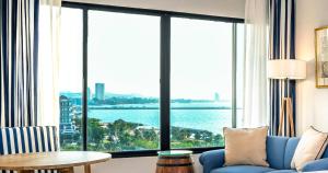 纳仲天Ocean Marina Resort Pattaya Jomtien的客厅设有蓝色的沙发和大窗户