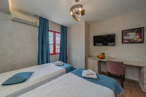 贝尔格莱德Hotel City Code Vizura garni RENEW的酒店客房配有两张床和一张书桌