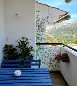 瓜达莱斯特EL ÚNICO apartment with jacuzzi and art的阳台设有蓝色长椅和鲜花墙