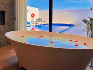 JawwJaw Resort & Spa的带浴缸的客房,设有游泳池