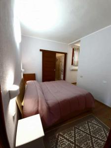 MarongiuVilla Quattro Archi的一间卧室配有一张床、一张桌子和一盏灯